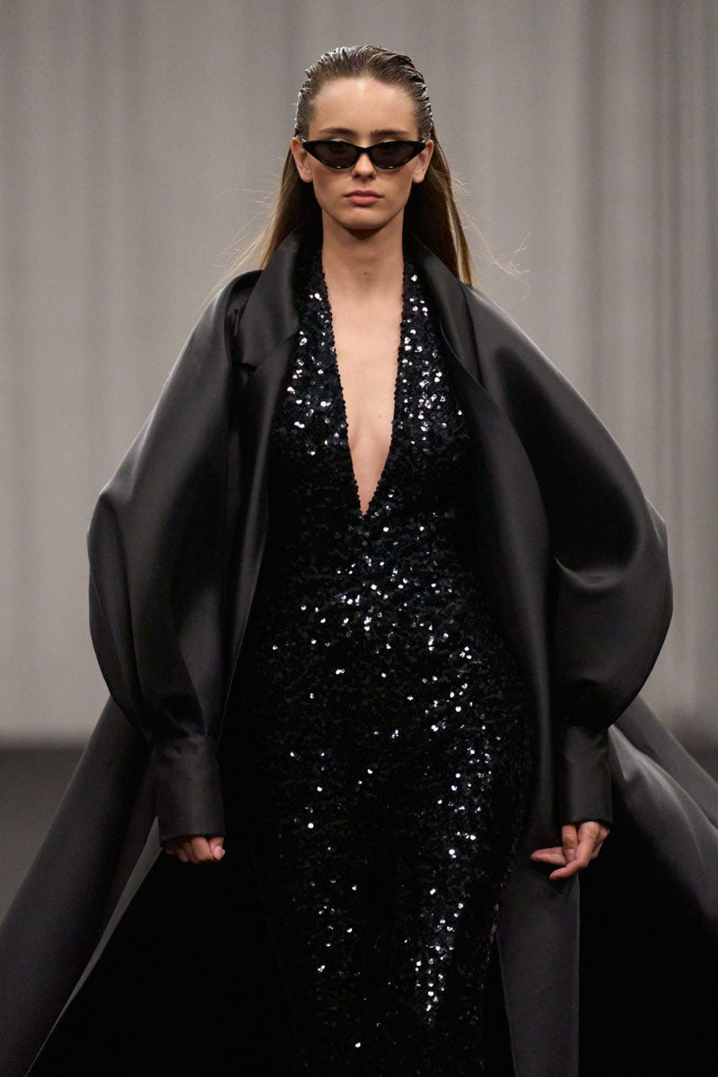 Lili Blanc fluid longline overcoat displayed hanging, showcasing its sleek, elegant design and lightweight fabric.