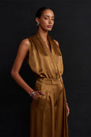 Acaria Studio Jill satin pants in copper color, featuring a sleek, smooth fabric and stylish fit, shown on a model.