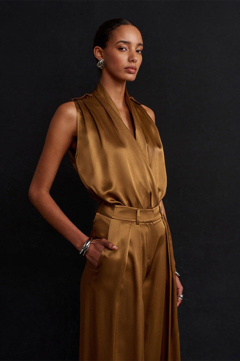 Acaria Studio Jill satin pants in copper color, featuring a sleek, smooth fabric and stylish fit, shown on a model.