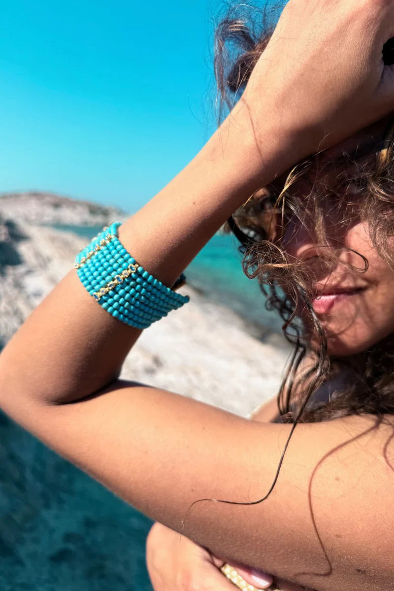 Turquoise Patmos Waves cuff bracelet by Peracas featuring intricate wave patterns and a sleek metal finish.