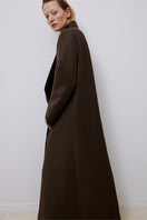 Tagg brown oversized double-breasted wool coat displayed on a hanger, showcasing its classic design and warm fabric.