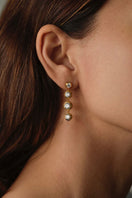 Pair of white MINI BELLA earrings by PERACAS, small and elegant jewelry with a minimalist design.