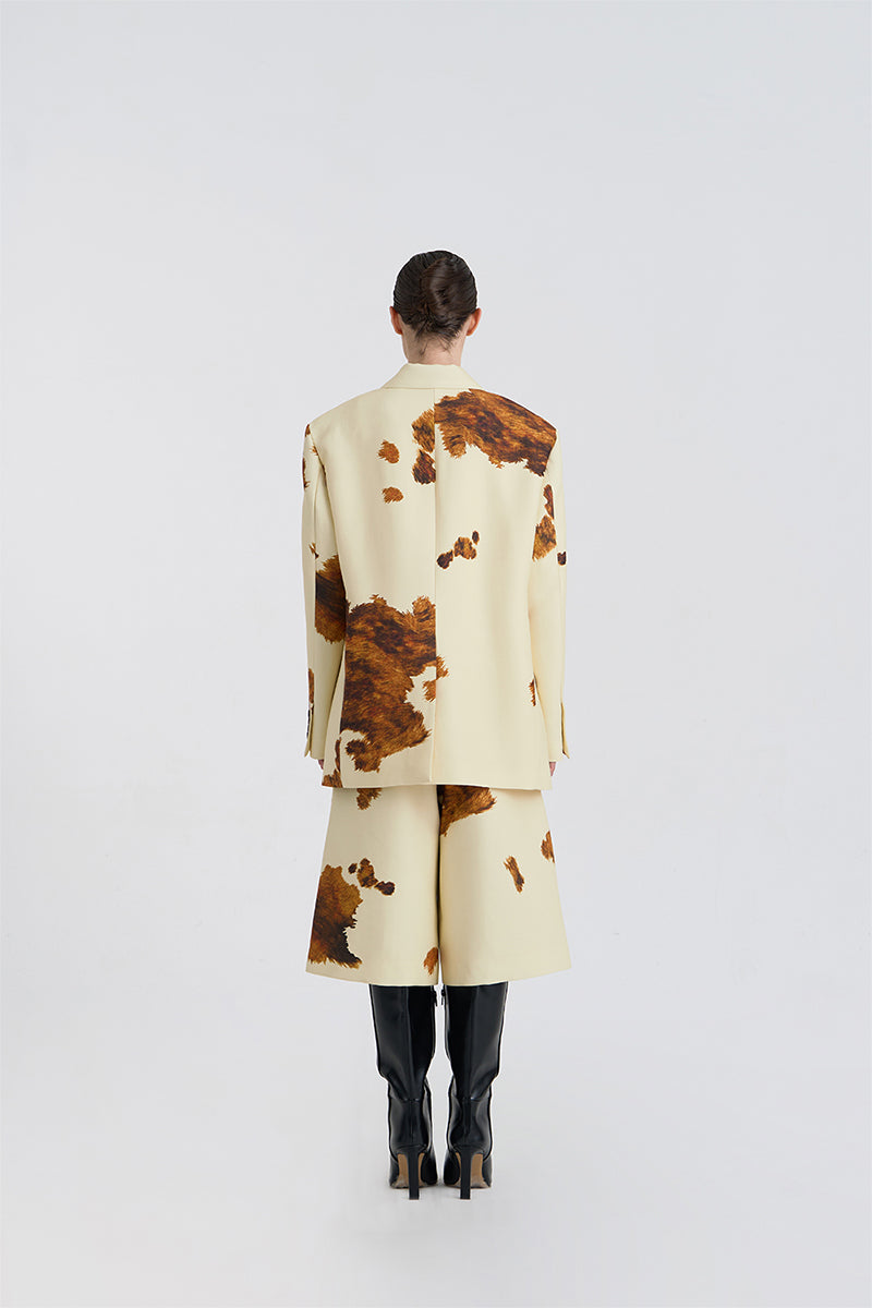 Back view of JINSUN printed wool silk Bermuda shorts in pale yellow, showcasing the relaxed fit and stylish design.
