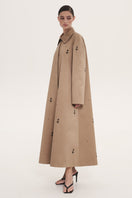 Beige rose embroidered trench coat by DELEGAN, showing detailed floral embroidery on lightweight fabric with classic collar and button closure.