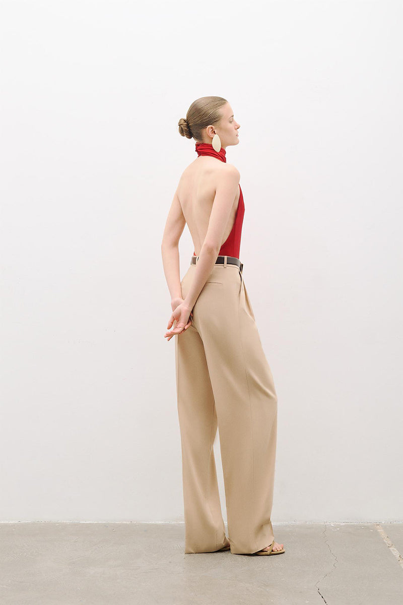 Red AWAVE turtleneck bodysuit with open back detail, form-fitting top showcasing sleek design and stylish neckline.