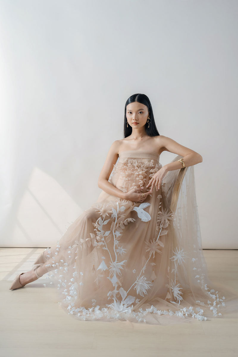 Elegant nude 3D-floral tulle gown by DOC BAN, showcasing a flowing maxi dress with intricate floral detailing and a graceful silhouette.