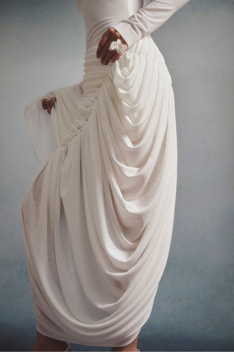 White Plan AURÉLIA draped maxi dress, featuring flowing fabric and elegant design, displayed on a hanger against a neutral background.