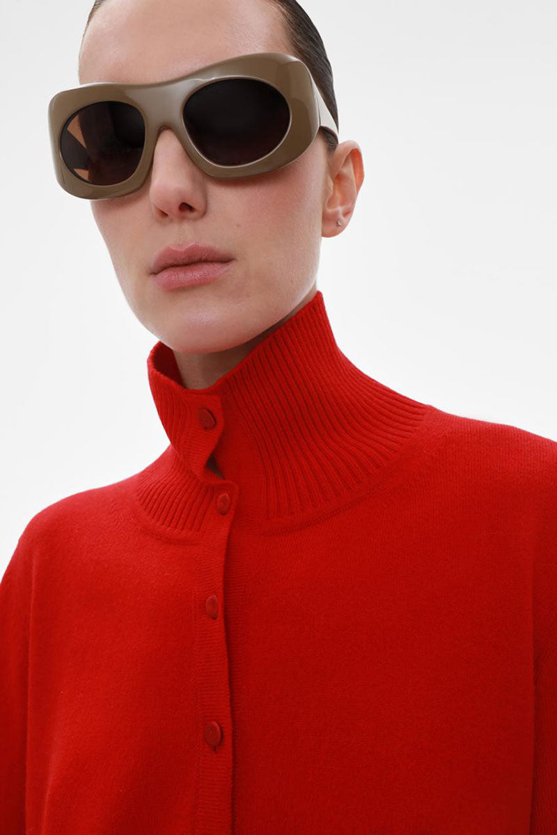 Elenareva red cashmere knit cardigan displayed on a hanger, showcasing soft, luxurious fabric and classic button closure.