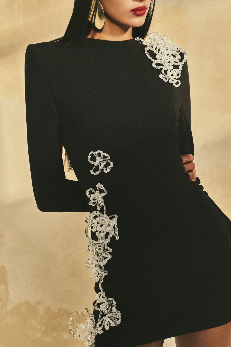 L'SCARLETT long-sleeve poly crepe mini dress shown in black, featuring a fitted silhouette and round neckline.
