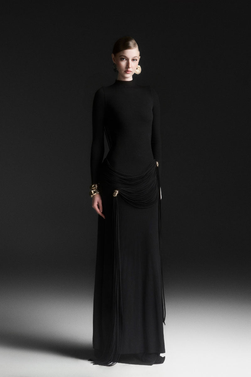 Maison Des Copains black high neck floor length maxi dress displayed on a model with elegant flowing fabric in a sleek design.
