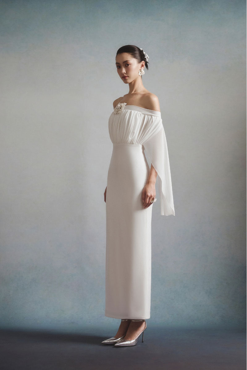 White Plan Elara off-shoulder maxi dress with flowing fabric and elegant design, shown on a model.