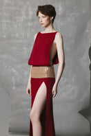 Red wine-colored slit gown by Phan Huy featuring a wide back strap and elegant flowing fabric.
