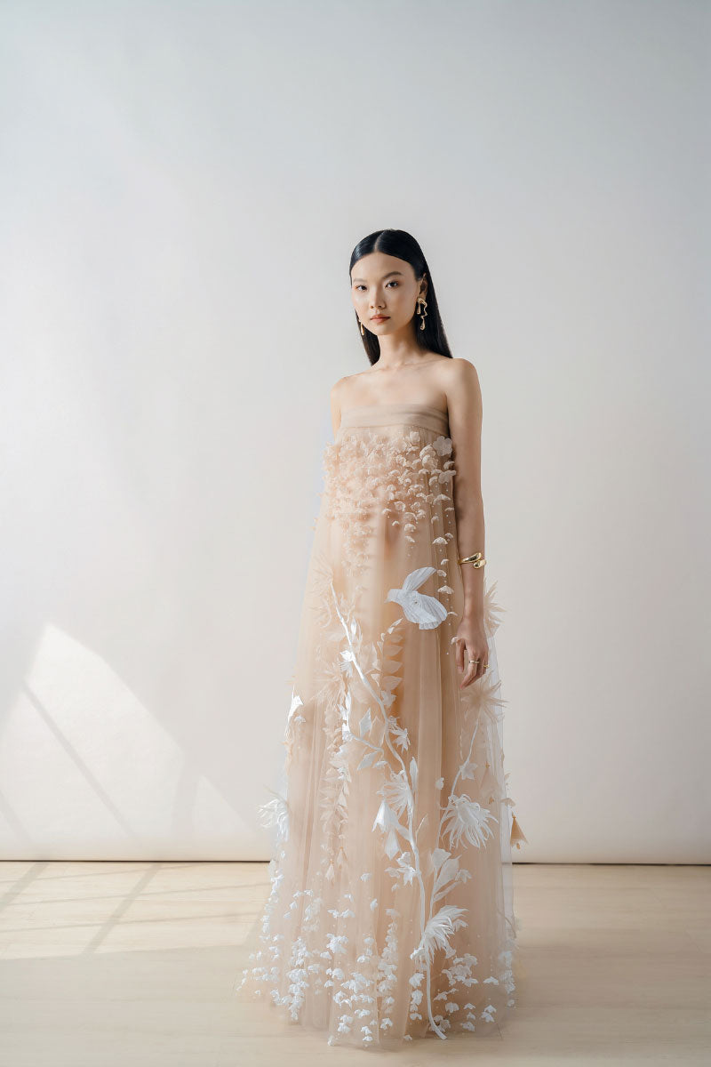 Nude 3D-floral tulle maxi dress by DOC BAN featuring layered floral details and flowing tulle fabric.