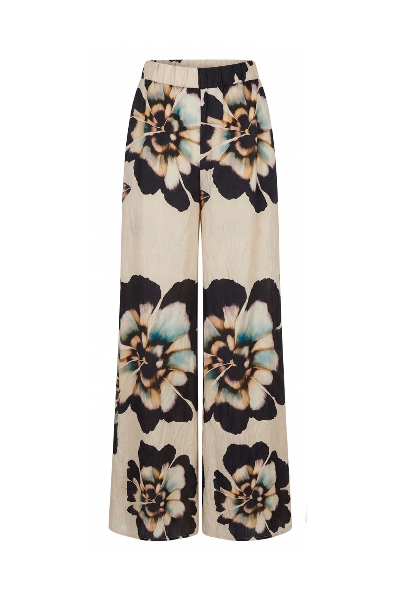 Sisters Alora pants in sandstone beige, showcasing relaxed fit and soft fabric, styled with a casual top and accessories.