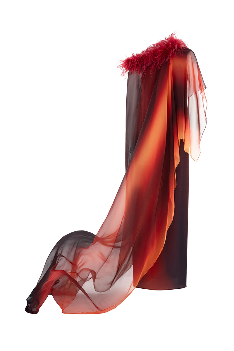 Orange printed gown with detachable ostrich feather trim cape by Valenciani, featuring elegant flowing fabric and detailed design.