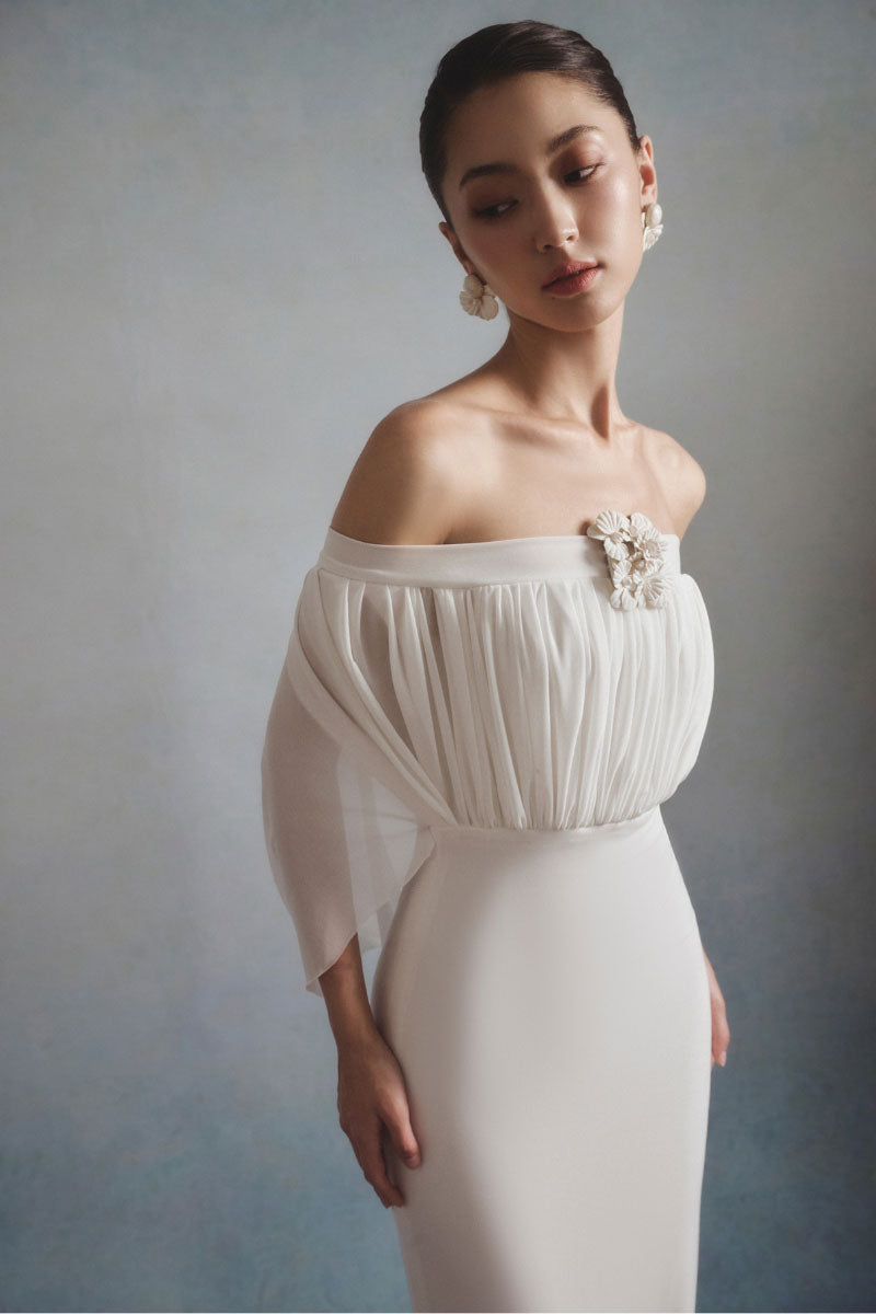 White Plan ELARA off-shoulder maxi dress featuring a flowing silhouette and elegant design, perfect for summer or formal occasions.