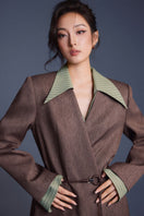 Keira Tong tailored cinched shirt featuring a fitted design, with a collared neckline and button-up front, displayed on a hanger.
