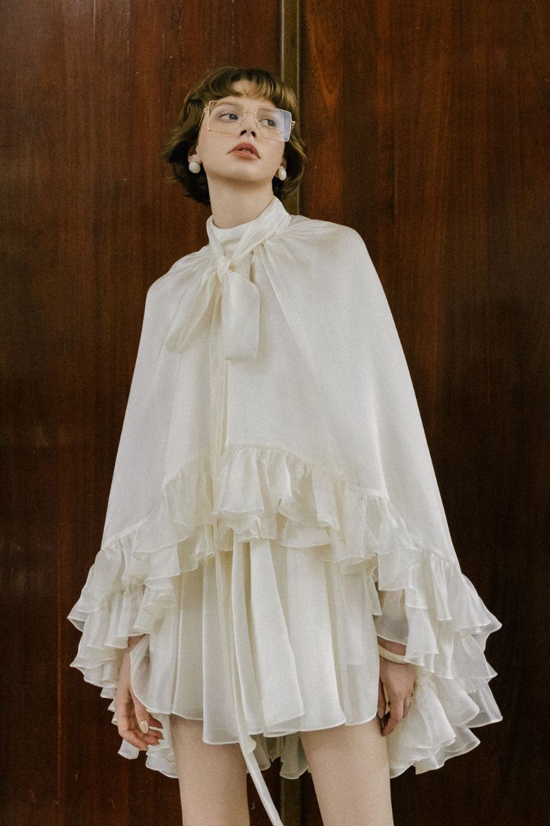 White Plan Monarch Mini Dress displayed on a hanger, showcasing its stylish design and fabric details.