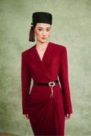 White Plan Crimson Muse gown featuring elegant red fabric, flowing design, and intricate detailing on a dress mannequin.