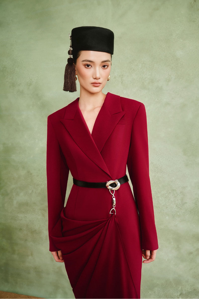 White Plan Crimson Muse gown featuring elegant red fabric, flowing design, and intricate detailing on a dress mannequin.