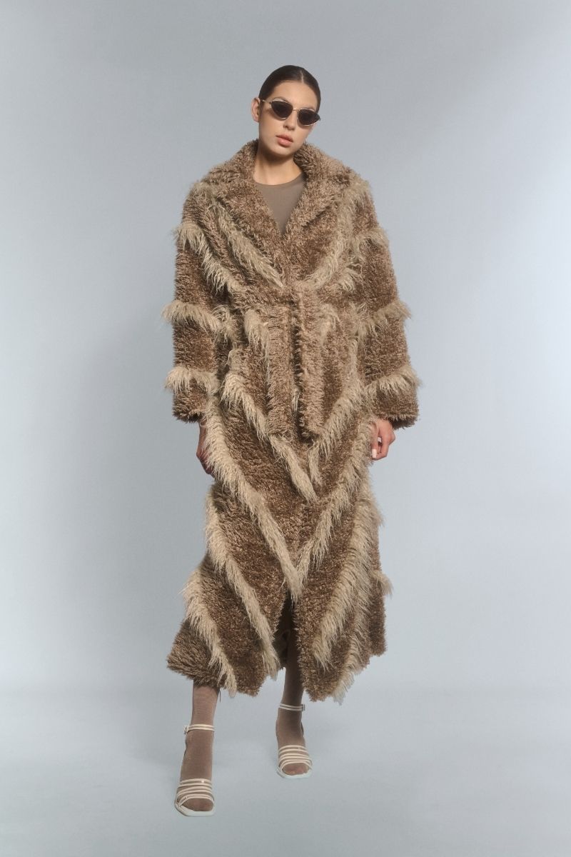 Beige faux fur maxi coat with diagonal panel design by Fortini, showing the plush texture and stylish silhouette.