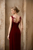 Elegant crimson velvet gown by Rosee de Matin featuring a flowing design and floral rose accents.