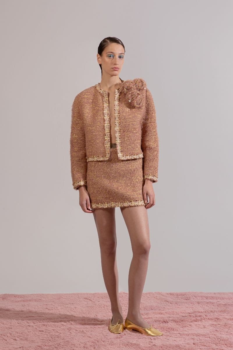 Lalo Rozany beige knitted mini skirt displayed on a model, showcasing its fitted style and soft knit texture.