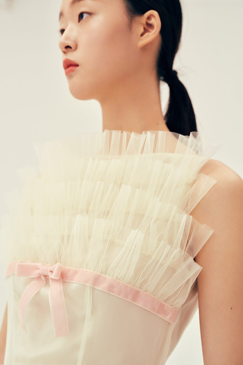 Chictopia Deborah ivory midi dress displayed on a hanger, showcasing elegant sleeveless design and flowing fabric.