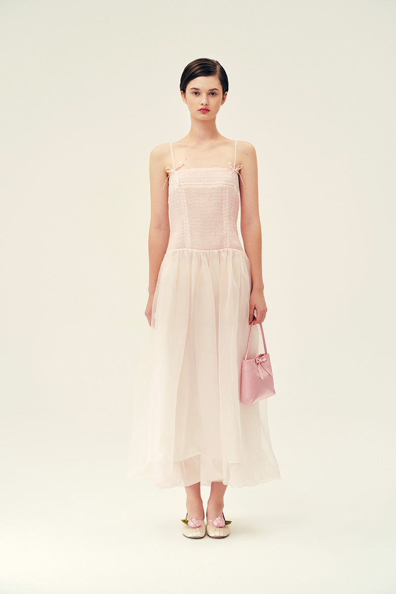 Light pink Cynthia maxi dress by Chictopia displayed on a hanger with flowing fabric and delicate design details.