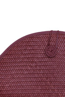 Adriana Castro La Barca leather clutch in deep burgundy with sleek design and gold-tone accents on smooth leather surface.