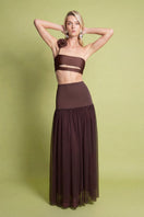 Brown Delfina maxi skirt by Laura Escobar, flowing fabric and elegant design, shown on a model.