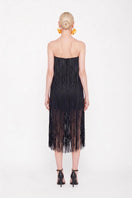 Black Valenciani all-over fringe midi dress featuring flowing fabric and fringe details, styled for a stylish occasion.