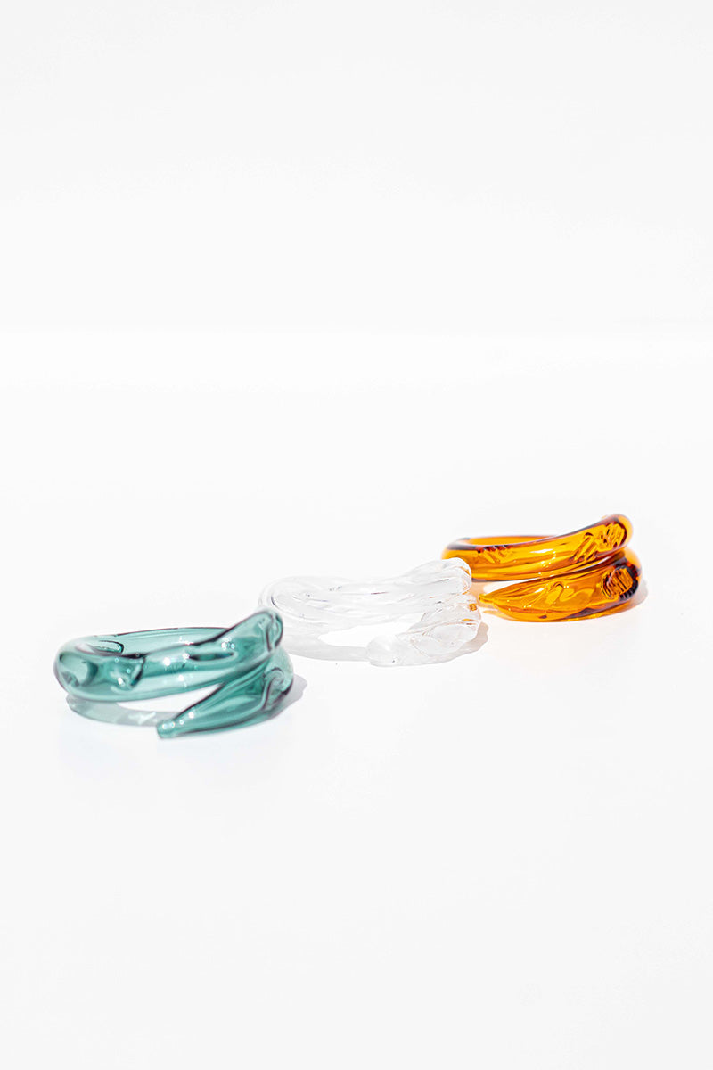 Set of three SALVÁREA rings featuring turquoise, amber, and white colors, showcasing intricate band designs on each ring.
