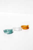 Set of three SALVÁREA rings featuring turquoise, amber, and white designs, showcasing intricate craftsmanship and vibrant colors.