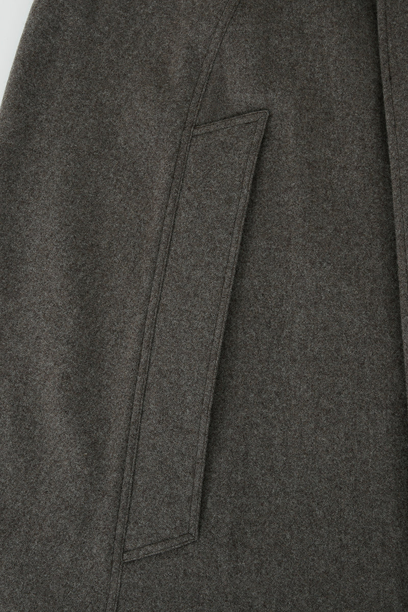 Brown long wool cape coat by JINSUN displayed on a hanger, showcasing its elegant, flowing fabric and classic design.
