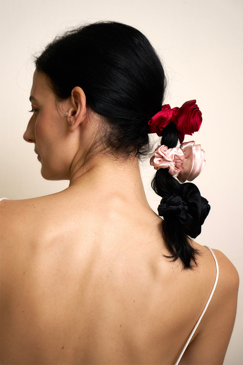 Three Tuscan Rose silk scrunchies from Not Just Pajama, soft pink silk hair accessories with a smooth, shiny finish.