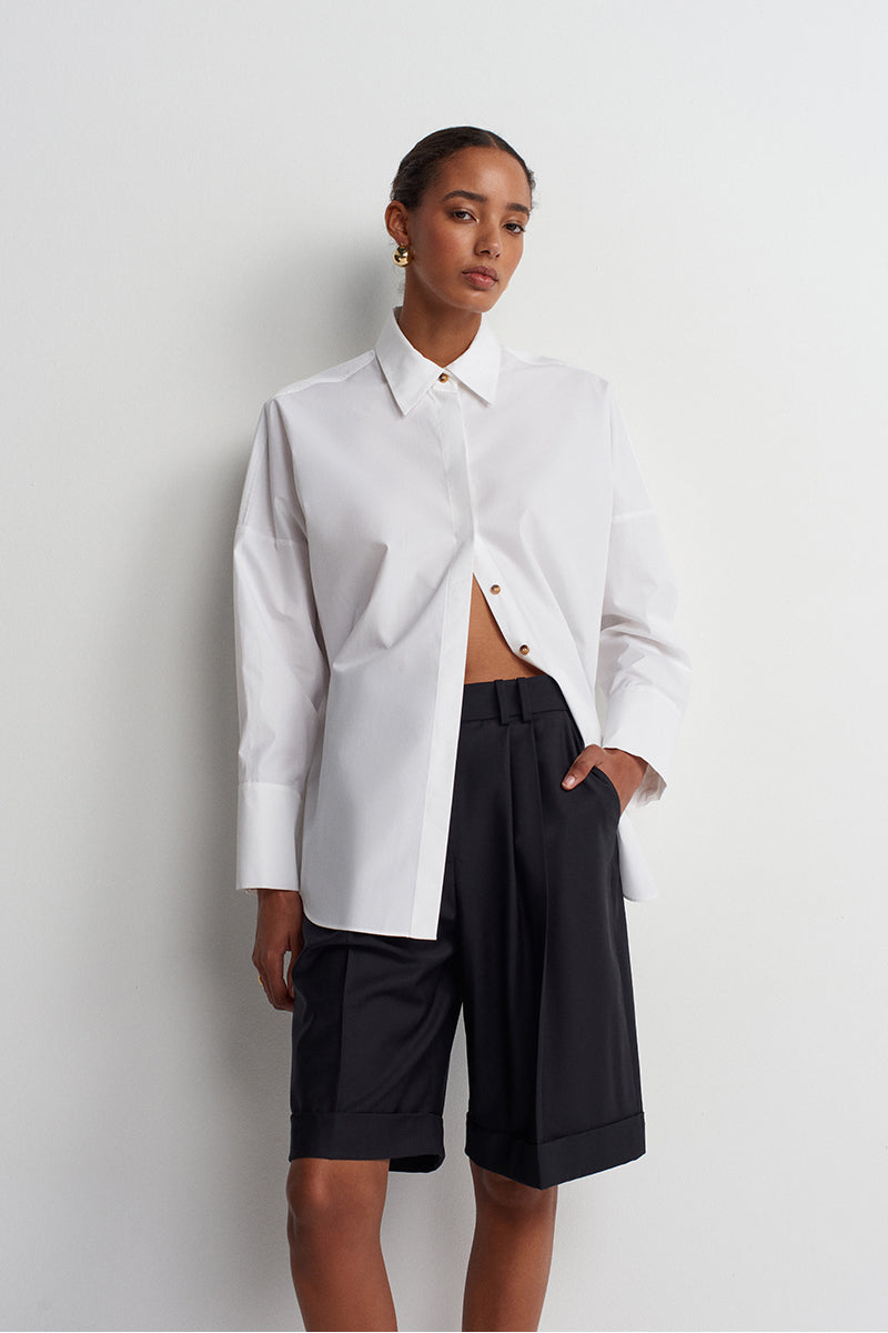 Acaria Studio Iconic Shirt displayed on hanger with button details and classic collar, showcasing modern men's shirt style.