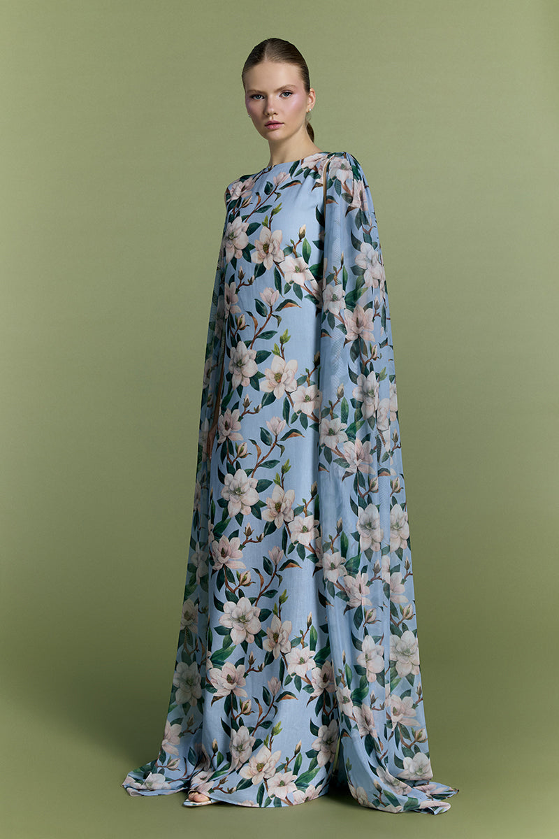 Nur Karaata Whisper Wind gown displayed on a hanger, featuring flowing fabric and elegant design details.