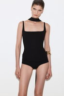 Black matte silk corset top with straps from BALYKINA, featuring a fitted design and smooth fabric detail.