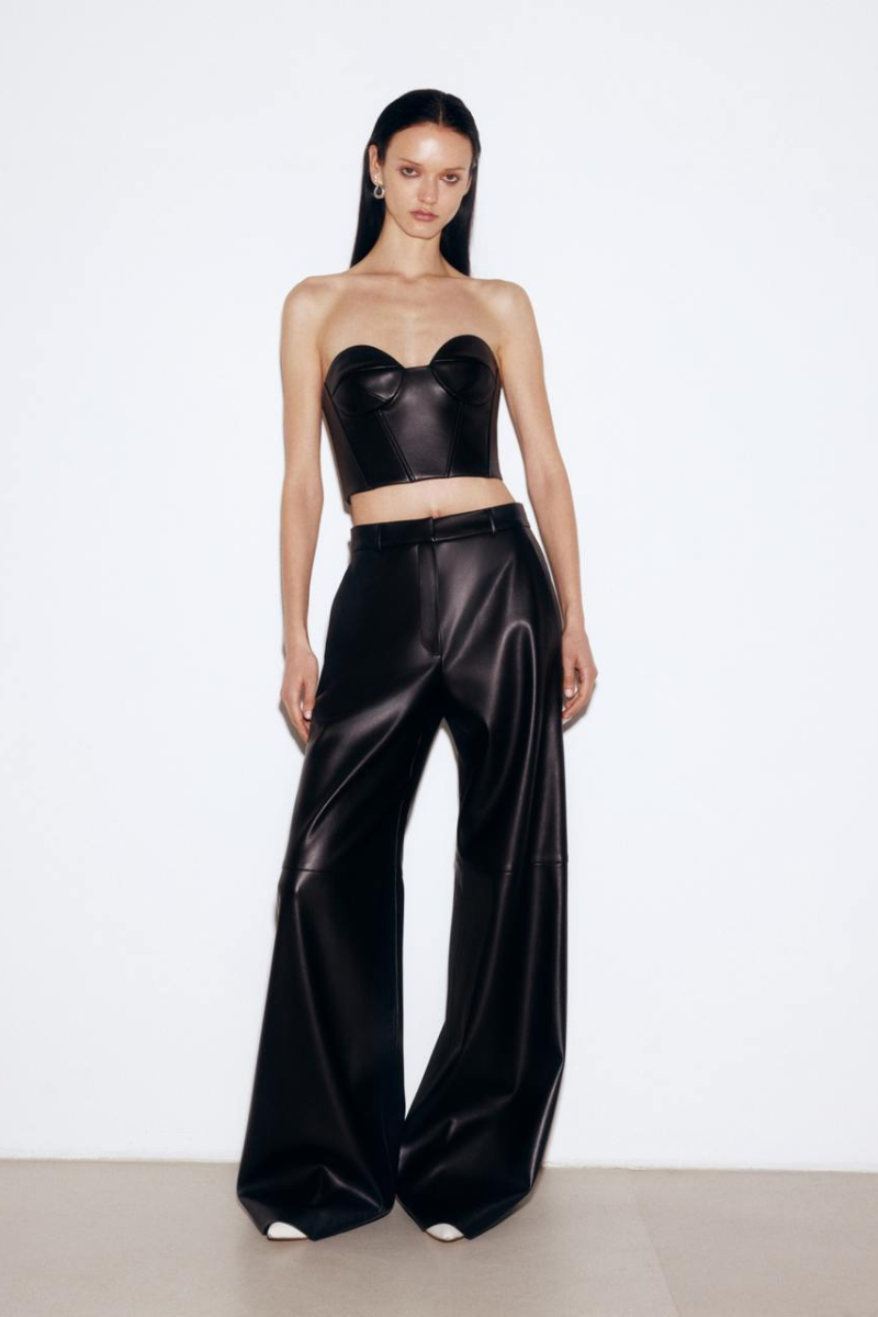 Black faux leather mini corset top by ELENAREVA, close-up of fitted, stylish women’s fashion top with buckle details.