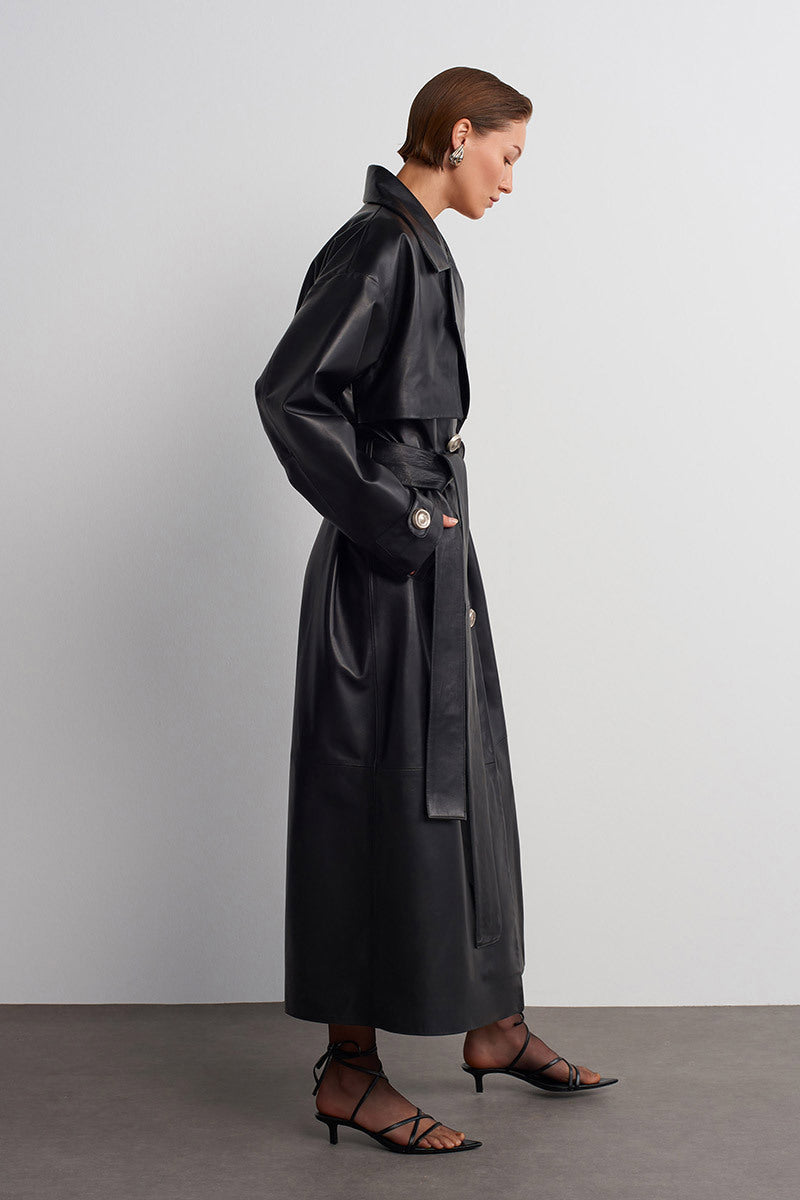 Black leather trench jacket from Acaria Studio's Journey collection, stylish and durable outerwear for women.