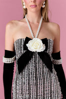 Nur Karaata Vivienne Rose mini dress, sleeveless with floral print, fitted waist and ruffled hem, on a model.