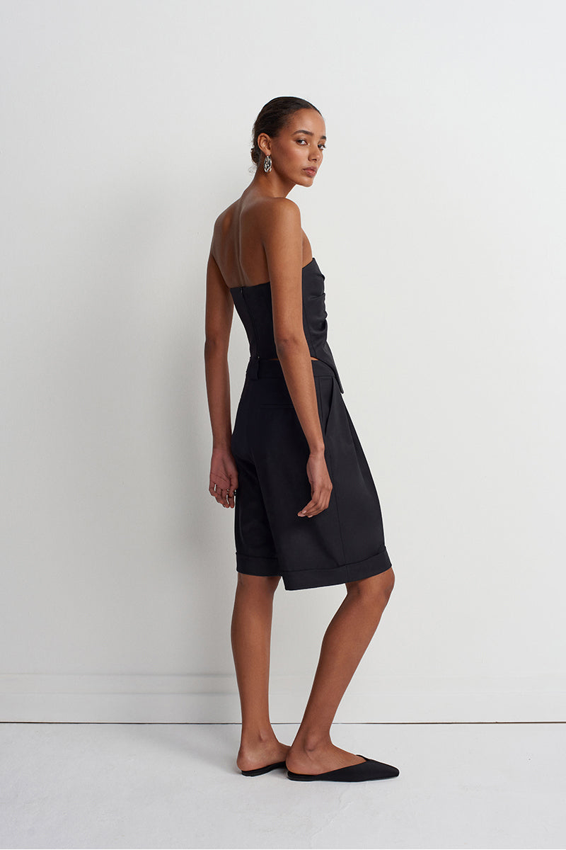 Black Acaria Studio Guru Shorts displayed on a model, showcasing their casual fit and stylish design.