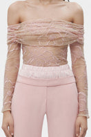 Pink sheer lingerie top by JC Pajares featuring delicate fabric and feminine design, displayed on a hanger.