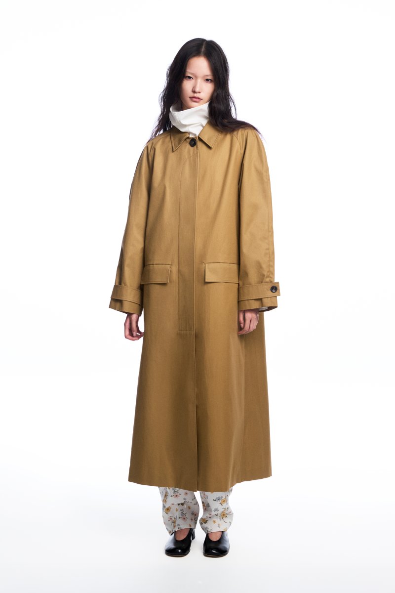 Long brown collared trench coat by Chictopia, shown hanging on a wooden mannequin with classic design and tailored fit.