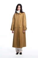 Long brown collared trench coat by Chictopia, shown hanging on a wooden mannequin with classic design and tailored fit.
