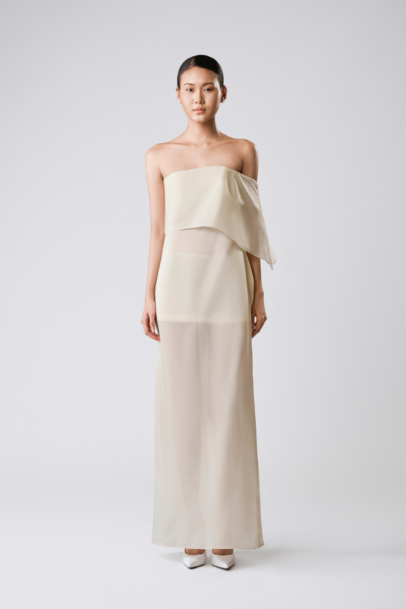 Light vanilla-toned TONYY maxi dress with draped design, flowing fabric, and sleeveless style, perfect for elegant summer wear.