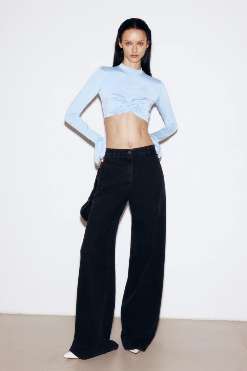 Black wide-leg jeans from ELENAREVA featuring a relaxed fit and classic denim style, shown hanging on a rack.