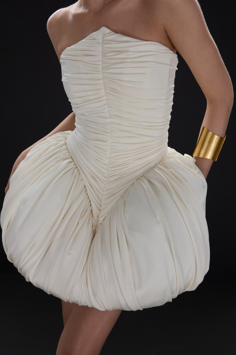 BalYKINA Clara Ivory Mini Dress displayed on a hanger, showcasing its elegant, short-sleeve design and lightweight fabric.