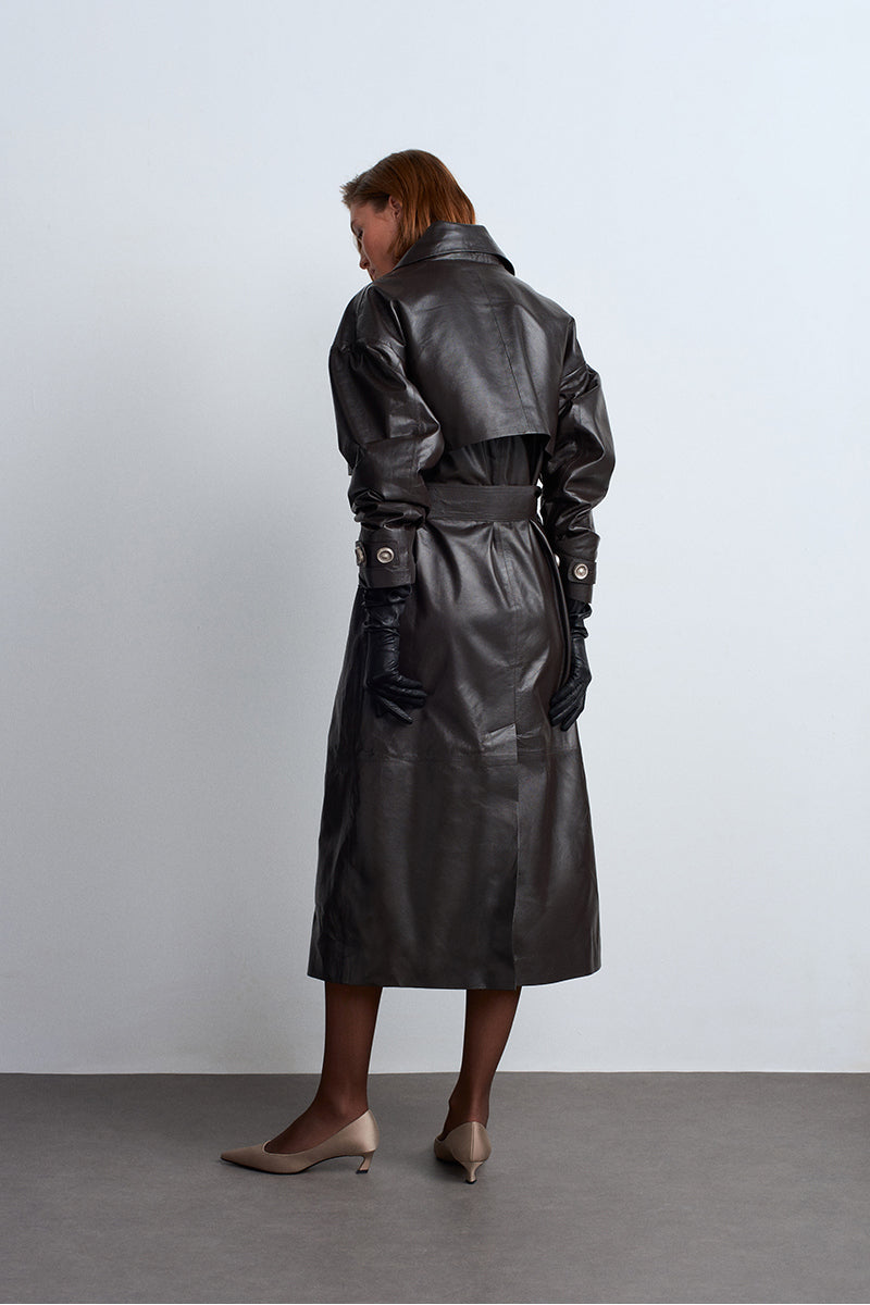 Dark brown leather trench coat from Acaria Studio, featuring classic design and tailored fit in a stylish outerwear piece.